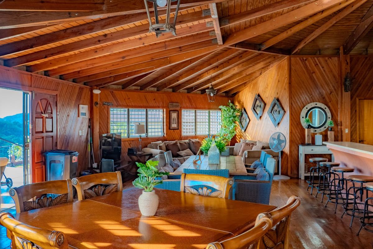 Gran salón de madera con techo catedral, comedor y sala en un solo espacio